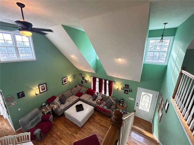living room featuring wood finished floors, a ceiling fan, and high vaulted ceiling