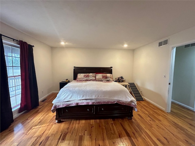 bedroom with visible vents, light wood-style flooring, and baseboards