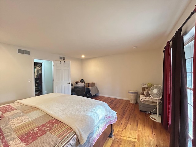 bedroom featuring visible vents, baseboards, and light wood finished floors