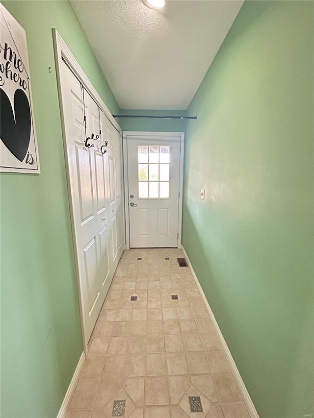 doorway with visible vents and baseboards
