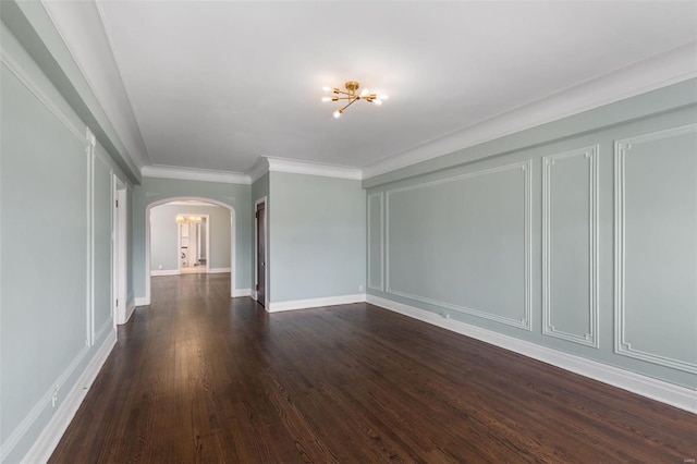empty room with crown molding, baseboards, arched walkways, dark wood-type flooring, and an inviting chandelier