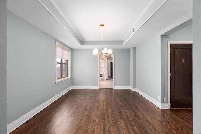 spare room featuring visible vents, a chandelier, baseboards, a raised ceiling, and dark wood-style floors