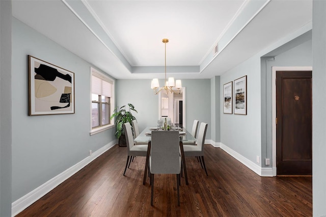 dining area with dark wood-type flooring, baseboards, a chandelier, a raised ceiling, and visible vents