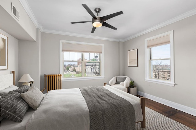 bedroom with radiator, crown molding, baseboards, visible vents, and wood finished floors