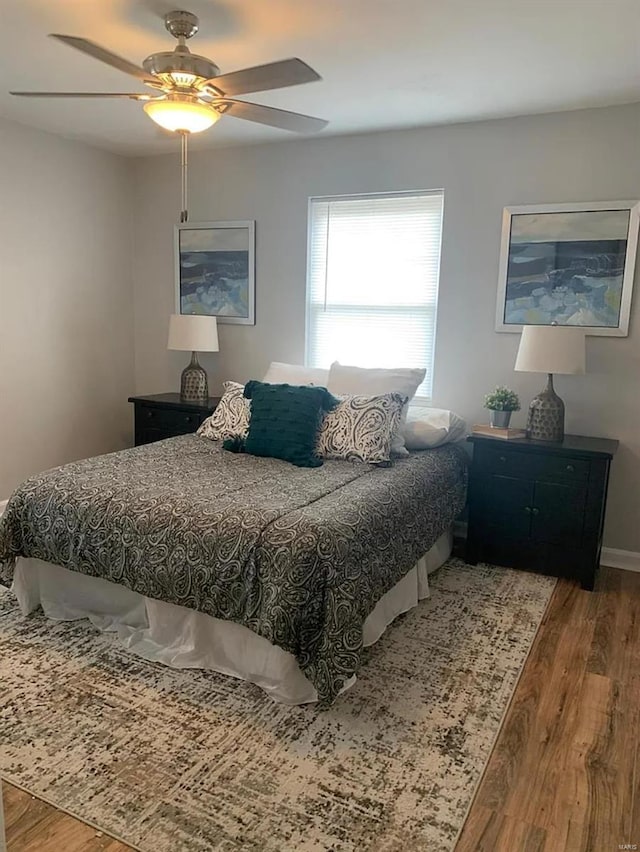 bedroom with wood finished floors, baseboards, and ceiling fan