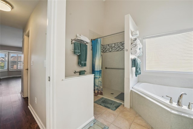 full bath with a garden tub, tile patterned floors, and a tile shower