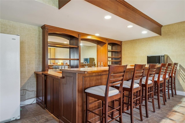 bar with freestanding refrigerator, stainless steel microwave, recessed lighting, and wallpapered walls