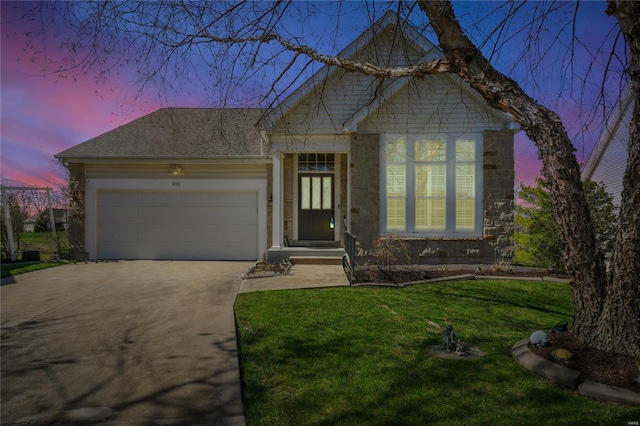 view of front of house with concrete driveway, a front lawn, stone siding, and a garage