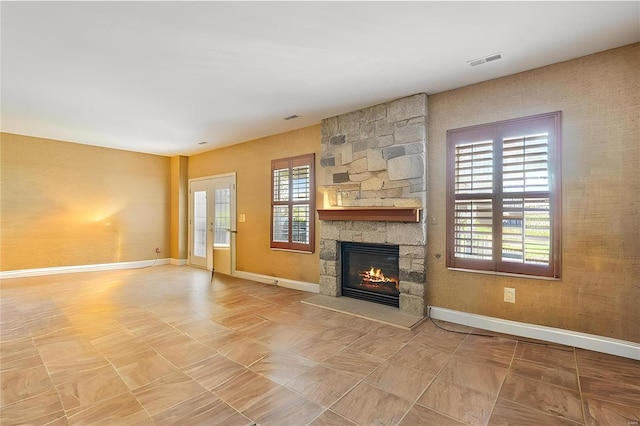 unfurnished living room featuring visible vents, baseboards, and a fireplace
