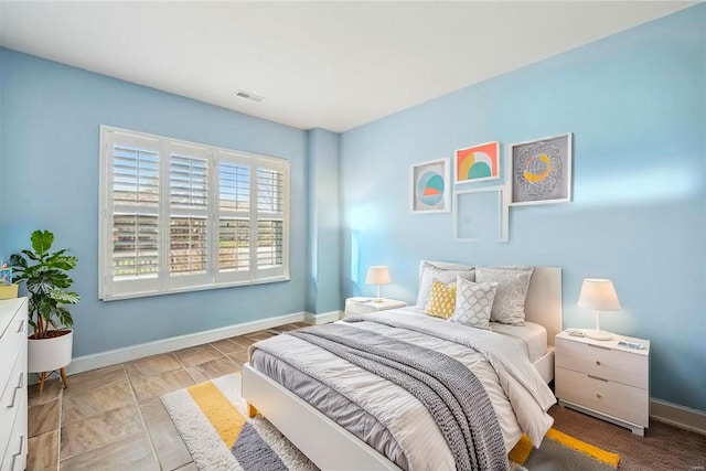 bedroom with baseboards and visible vents