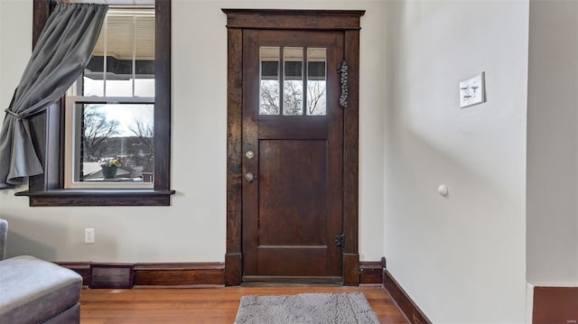 foyer with baseboards and wood finished floors