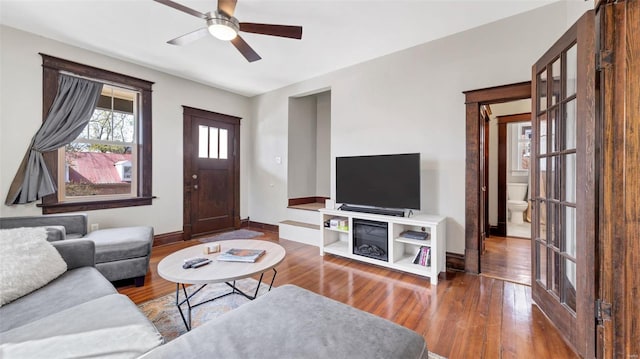 living room with baseboards, ceiling fan, and hardwood / wood-style floors