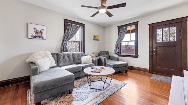 living area with baseboards, ceiling fan, and hardwood / wood-style flooring