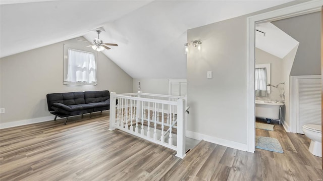 bedroom with baseboards, ceiling fan, wood finished floors, and vaulted ceiling