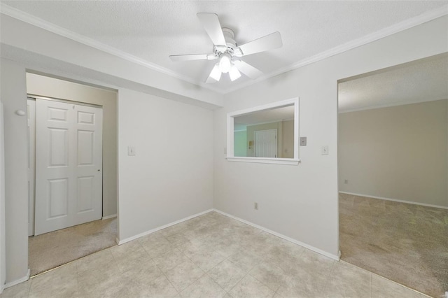empty room featuring a ceiling fan, light colored carpet, and ornamental molding