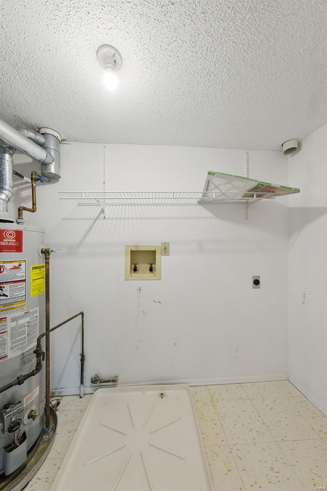 clothes washing area with a textured ceiling, tile patterned floors, gas water heater, laundry area, and washer hookup