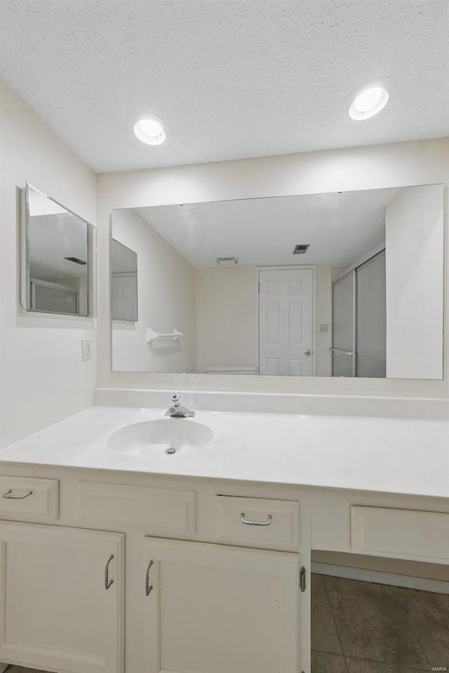 bathroom featuring tile patterned floors, a textured ceiling, visible vents, recessed lighting, and vanity