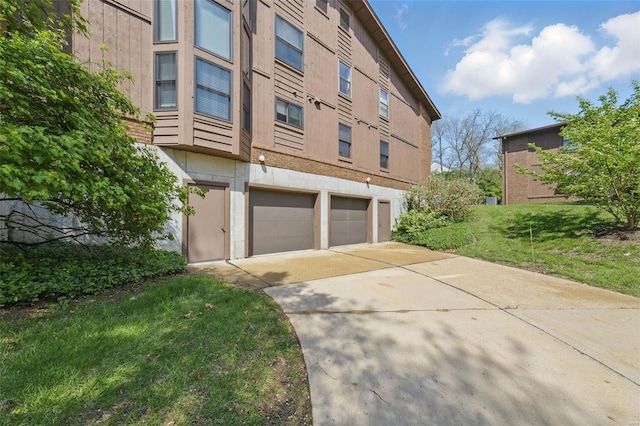 exterior space with a garage, a yard, and concrete driveway
