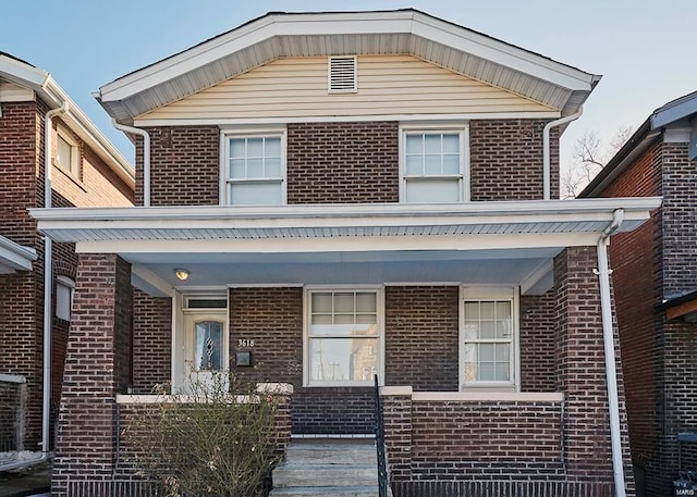 view of front of home with covered porch and brick siding