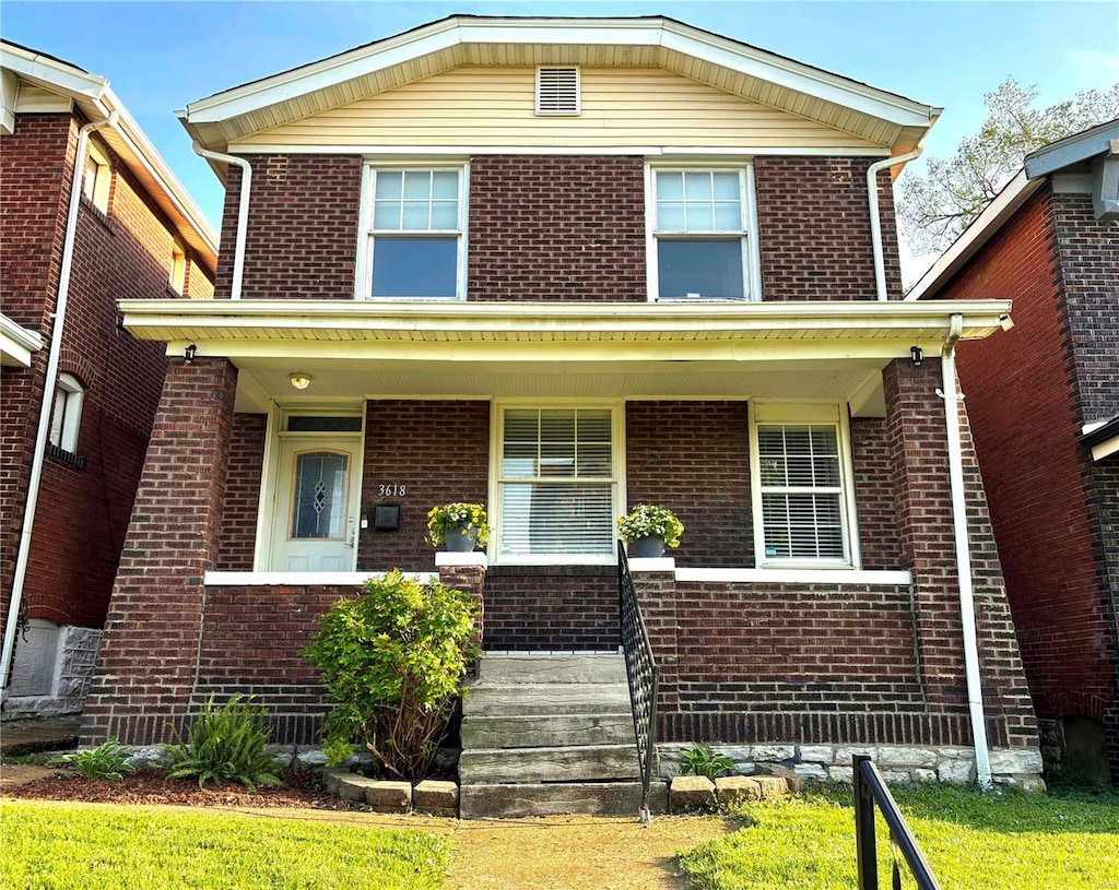 view of front of property with a porch and brick siding