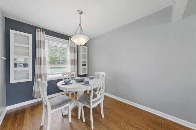 dining space featuring wood finished floors and baseboards