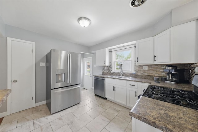 kitchen featuring a sink, white cabinets, stainless steel appliances, and tasteful backsplash