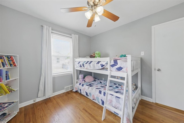 bedroom featuring wood finished floors, visible vents, and baseboards