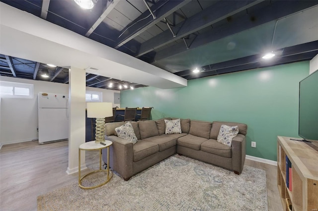 living room featuring baseboards, wood finished floors, and a dry bar
