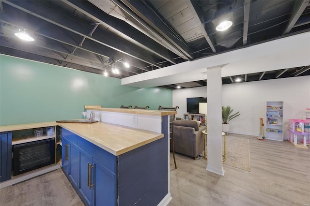 kitchen with light wood finished floors, blue cabinets, and open floor plan