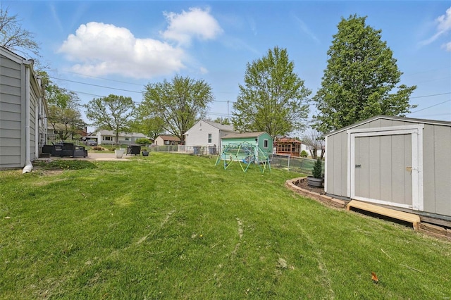 view of yard with fence, a storage shed, and an outdoor structure
