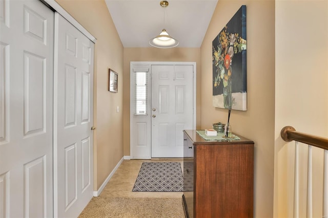 entrance foyer with vaulted ceiling and baseboards