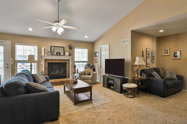 living area featuring lofted ceiling, visible vents, a ceiling fan, and light colored carpet