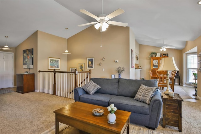 living area with light colored carpet, lofted ceiling, a ceiling fan, and baseboards