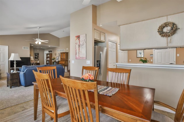 dining room featuring a ceiling fan, visible vents, high vaulted ceiling, and light colored carpet