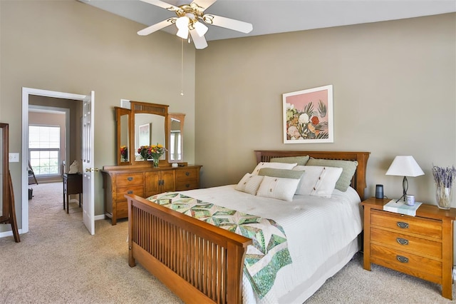 bedroom with ceiling fan, a towering ceiling, baseboards, and light carpet