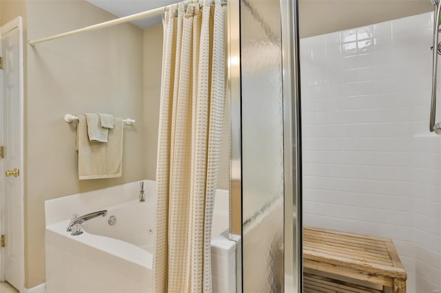 full bathroom featuring a garden tub and a stall shower