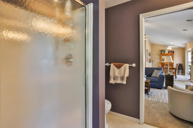 full bathroom with baseboards, a shower stall, ceiling fan, and toilet