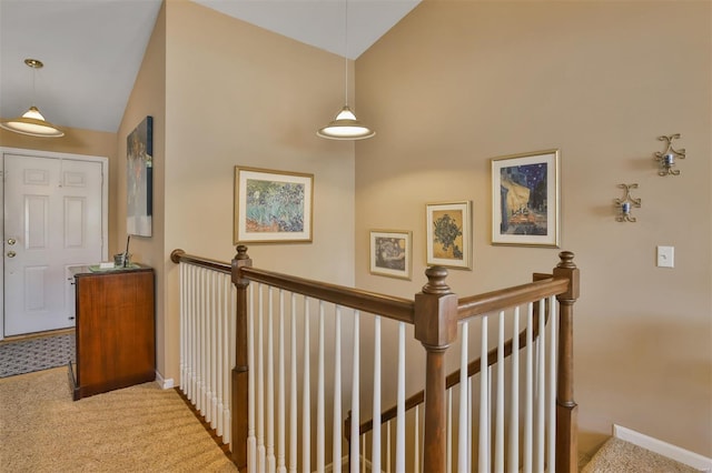 hall with lofted ceiling, carpet flooring, and baseboards