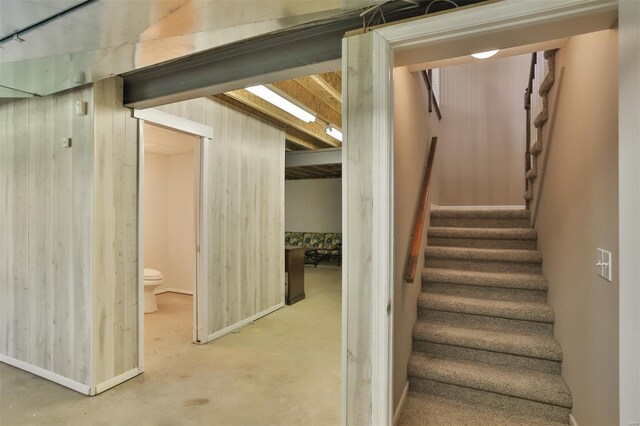 stairway featuring concrete floors and baseboards