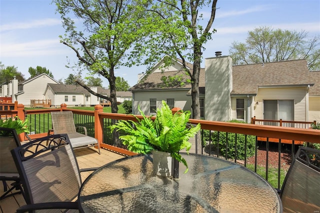 wooden terrace featuring a residential view and outdoor dining area