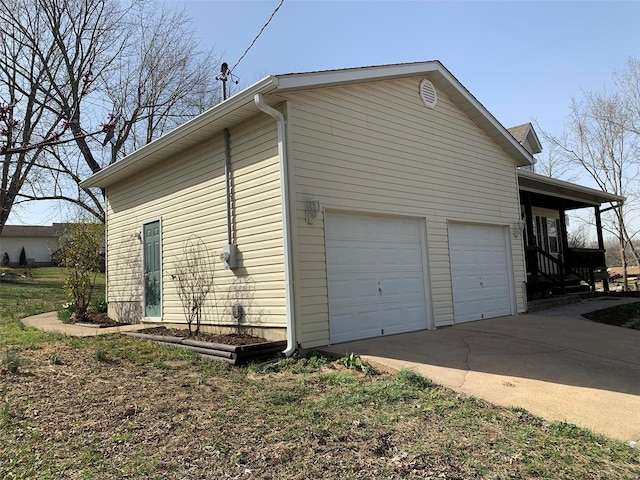 view of side of property featuring a garage and concrete driveway