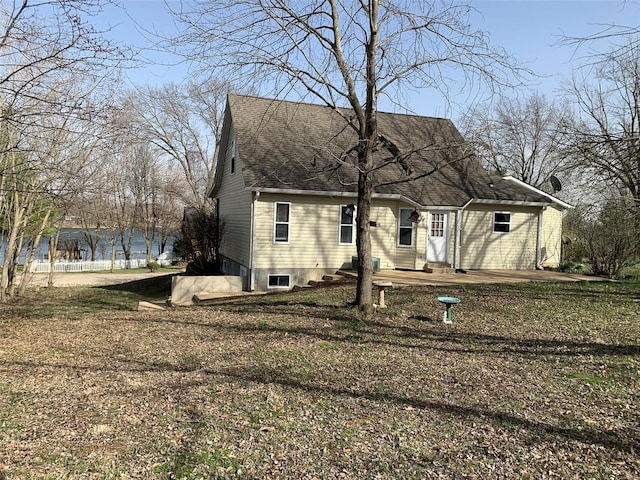 back of house featuring roof with shingles