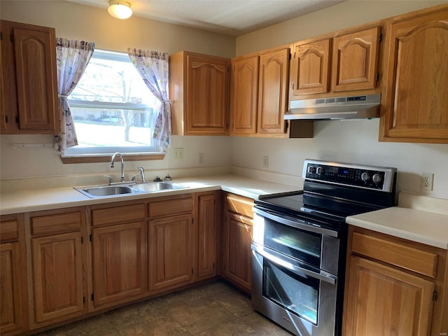 kitchen featuring light countertops, under cabinet range hood, double oven range, and a sink