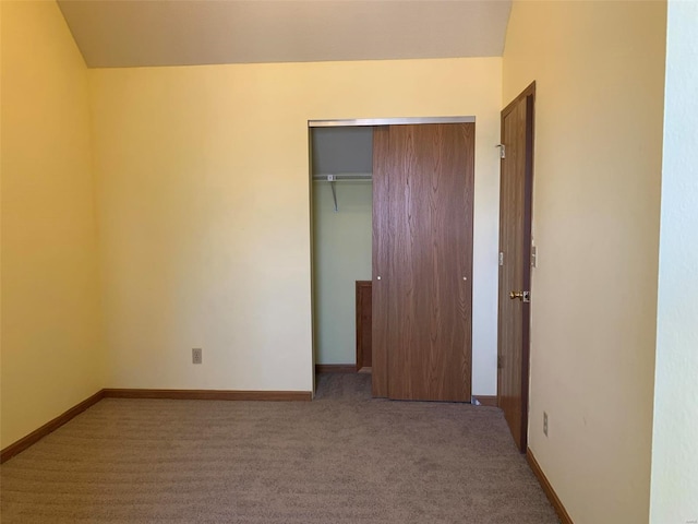 unfurnished bedroom with a closet, baseboards, and carpet