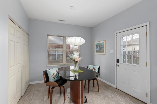 dining area with light tile patterned floors, baseboards, and visible vents
