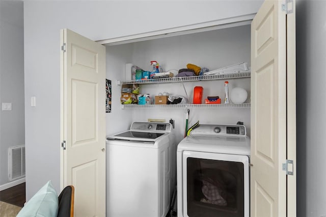washroom with laundry area, visible vents, and washing machine and clothes dryer