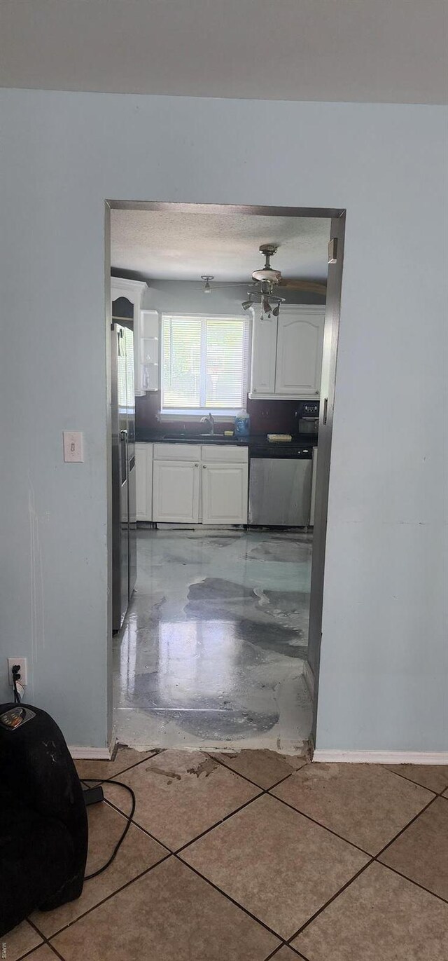 kitchen featuring baseboards, white cabinetry, a sink, and appliances with stainless steel finishes