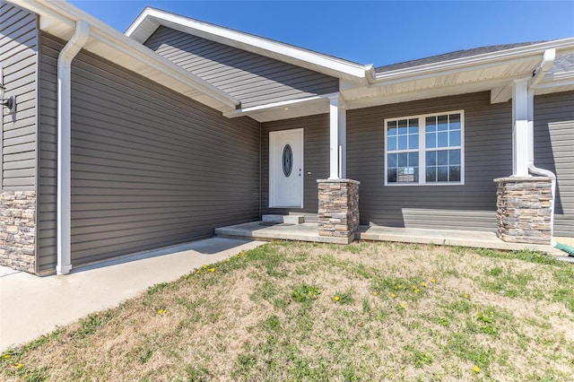 property entrance featuring stone siding and covered porch