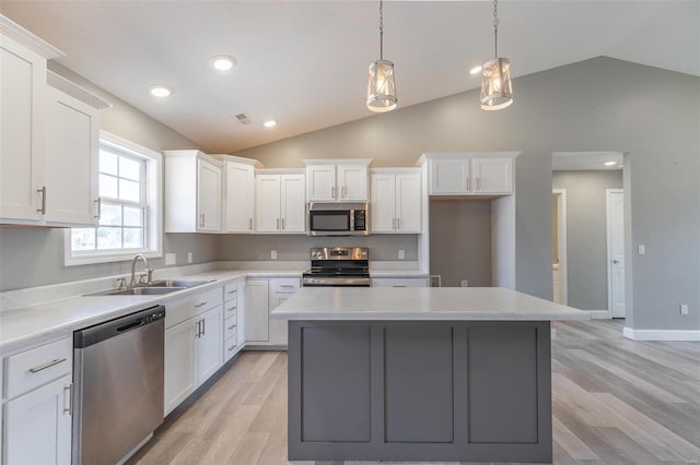kitchen featuring white cabinets, a sink, a center island, and appliances with stainless steel finishes