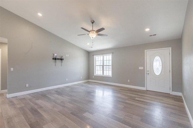 entryway featuring visible vents, baseboards, a ceiling fan, lofted ceiling, and light wood-type flooring